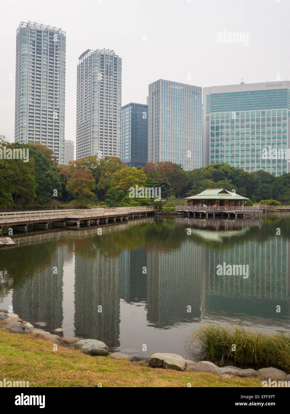 Hama Rikyu Onshi-teien reflected landscape with teahouse, trees and skyscrapers Stock Photo