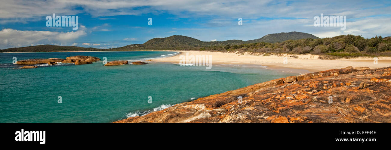 Panoramic view of sandy beach, turquoise waters of Pacific Ocean & bay hemmed by wooded dunes at South West Rocks NSW Australia Stock Photo