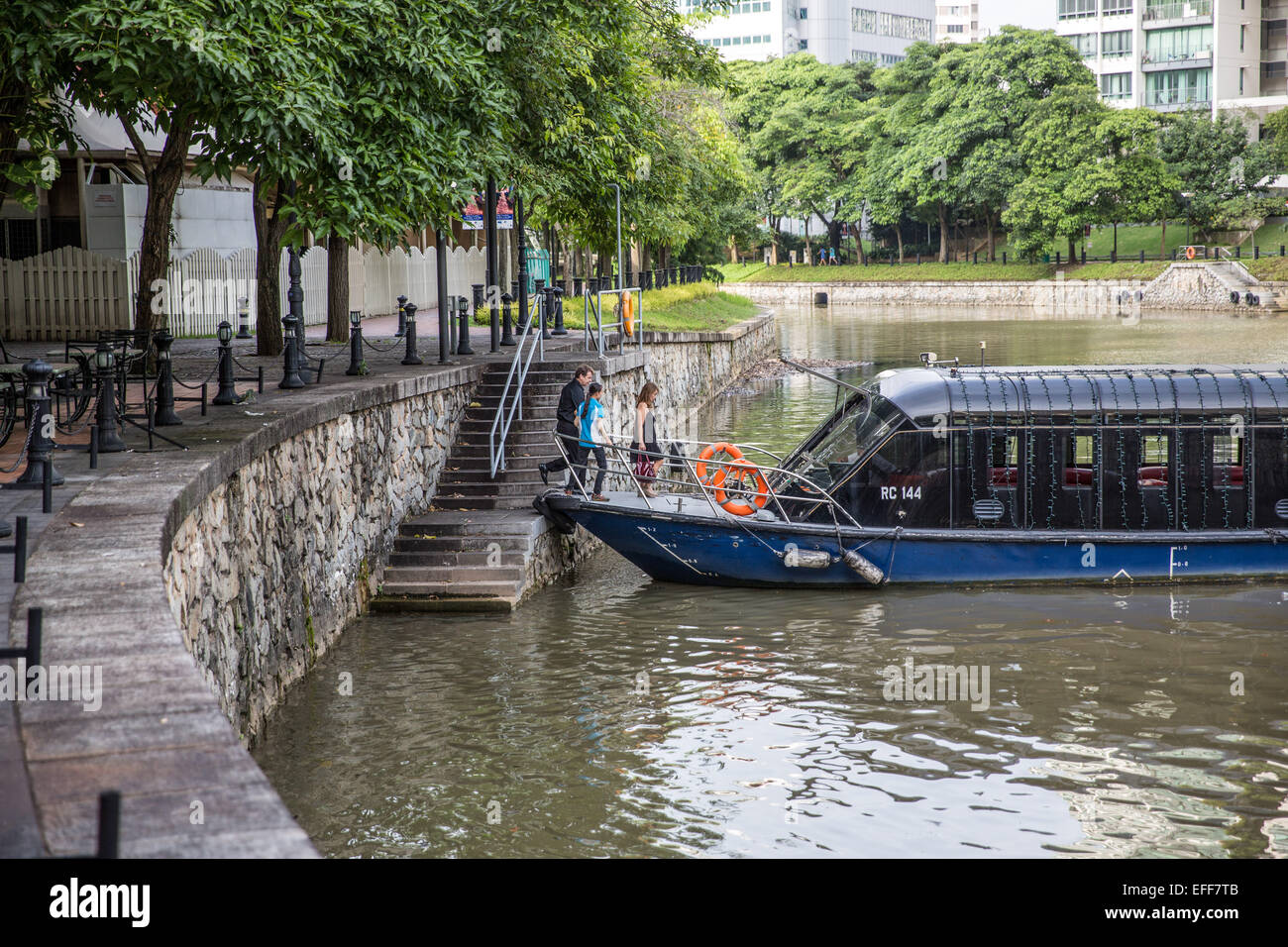 Passengers join a tourist water taxi boat on Singapore River Stock Photo