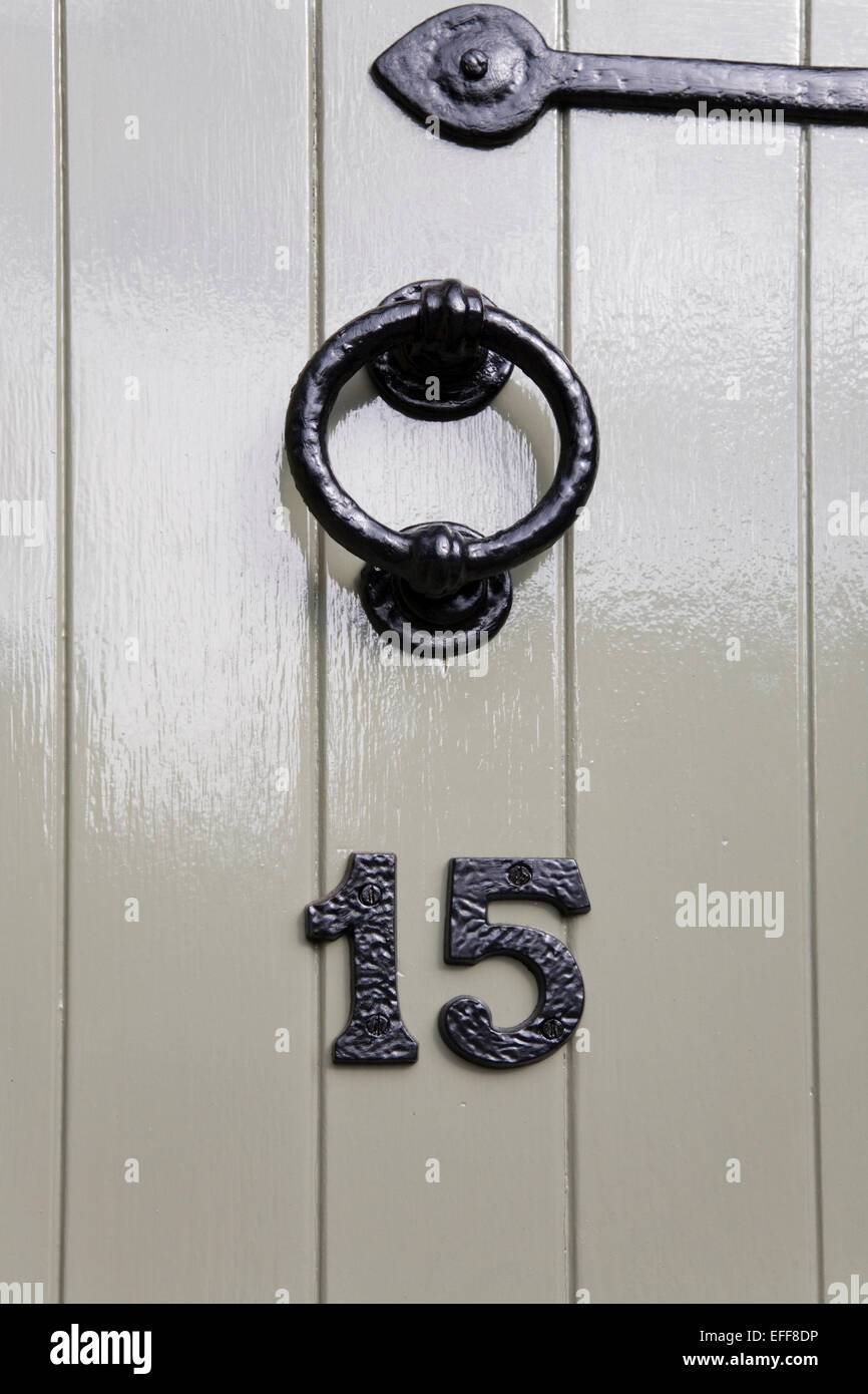 Grey door section with iron knocker and number 15 Stock Photo