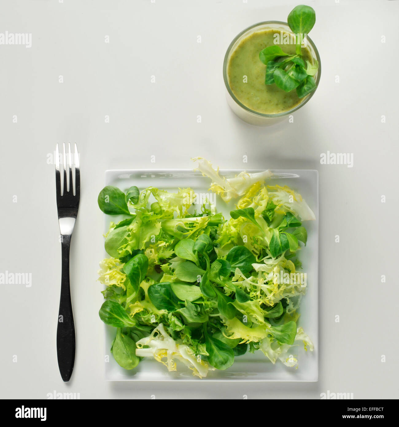 high-angle shot of a plate with a green and a green smoothie on a white table Stock Photo