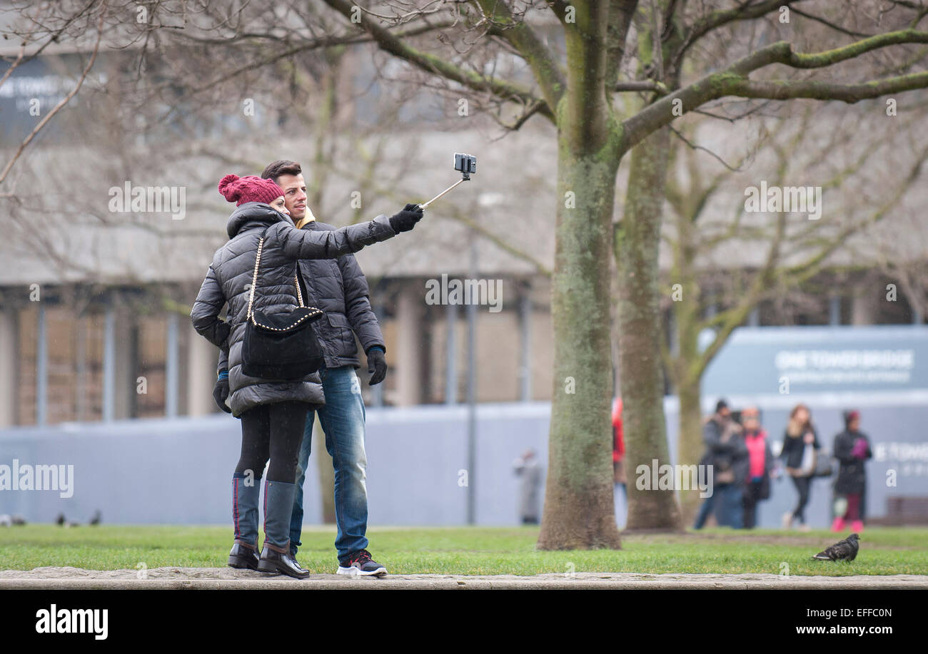 People taking a selfie with a selfie stick. Stock Photo
