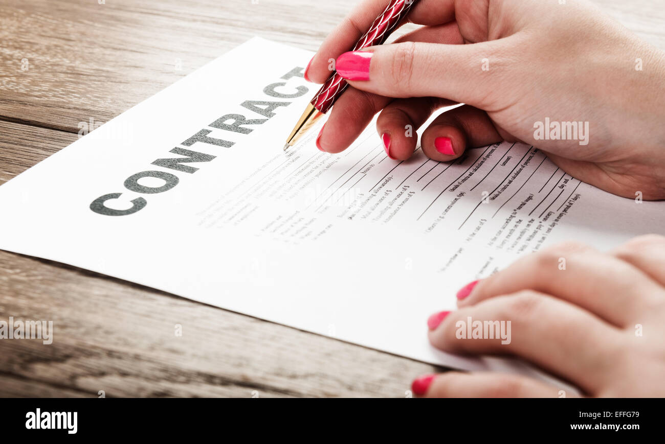 Businesswoman's hand with pen signing a contract Stock Photo - Alamy