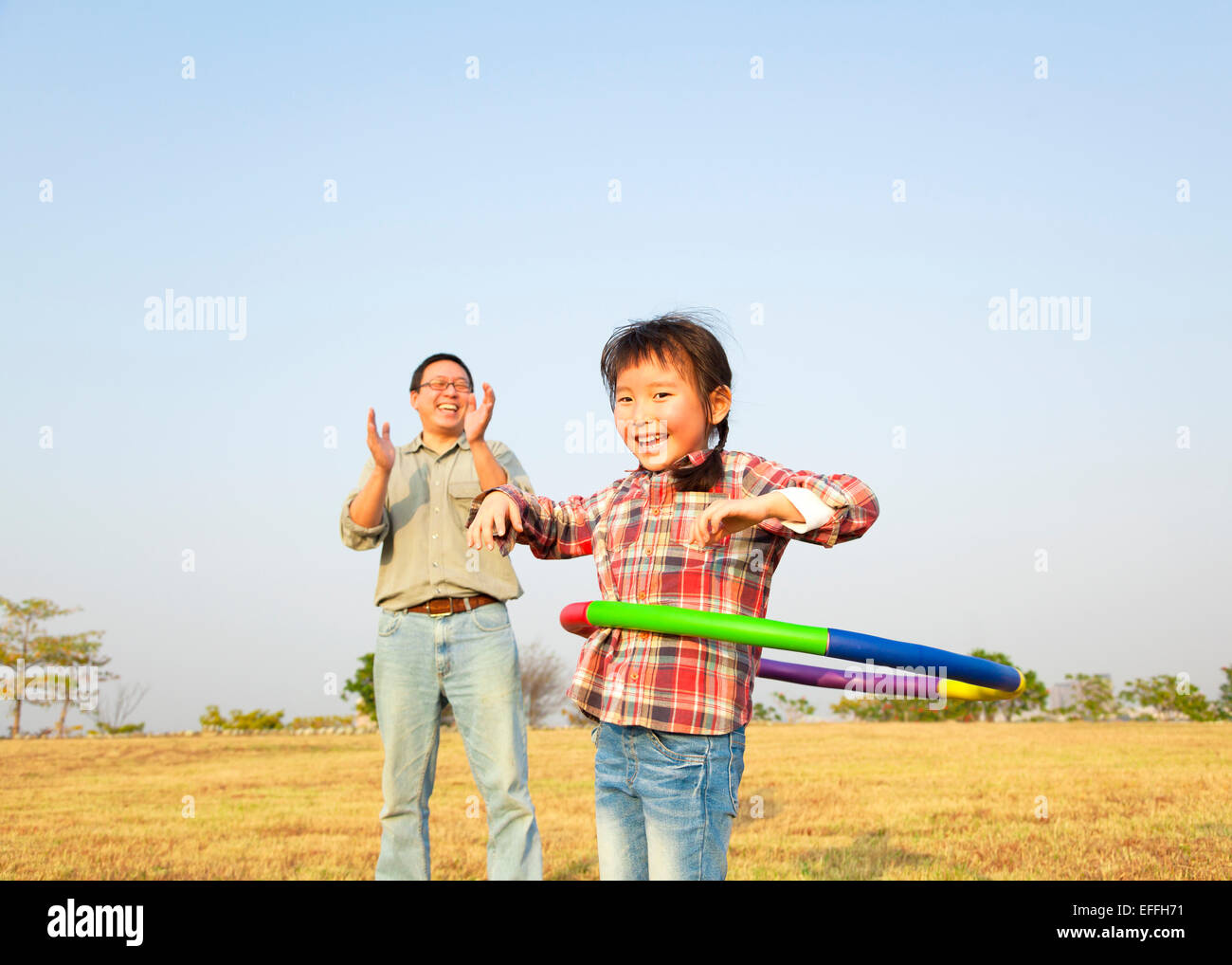happy little girl playing with hula hoops outdoors Stock Photo Alamy