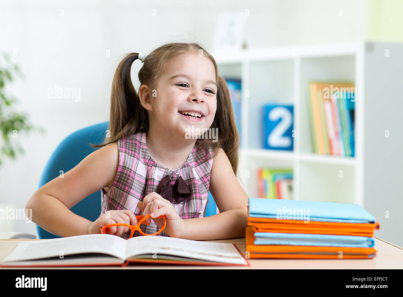 cute smiling kid reading book in children room Stock Photo