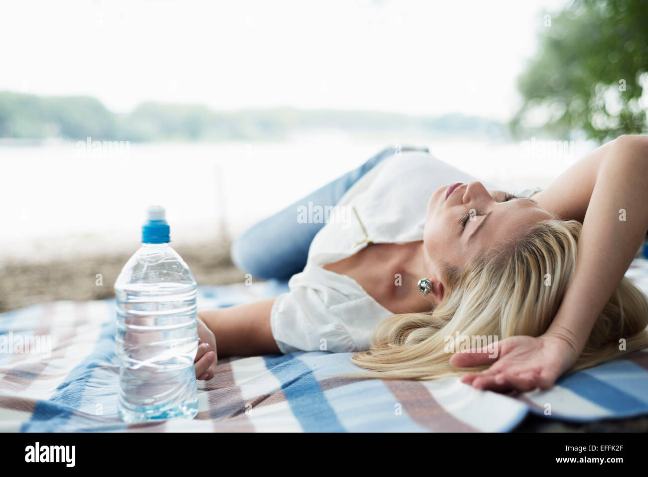 Young woman relaxing on a blanket on the beach Stock Photo Alamy