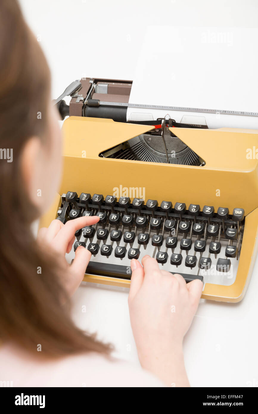Close-up of young woman using typewriter Stock Photo