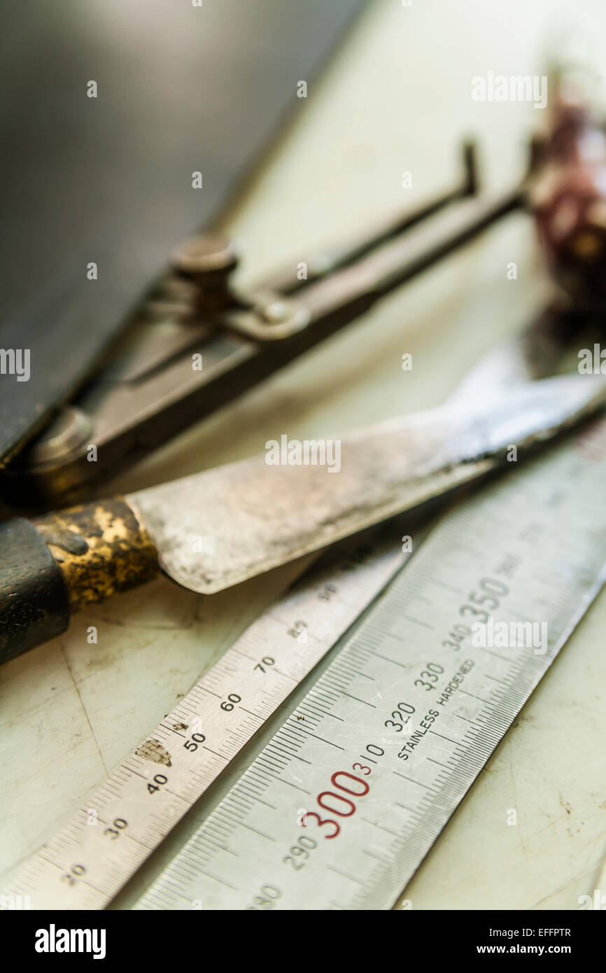 Saddlery tools, metal ruler, paring knife, awle ans compasses Stock Photo