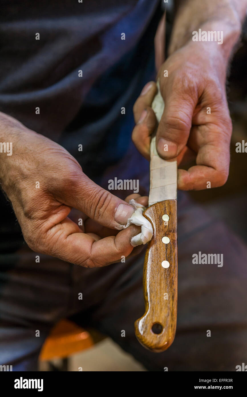 Knife maker rubbing linseed oil on knife handle Stock Photo Alamy