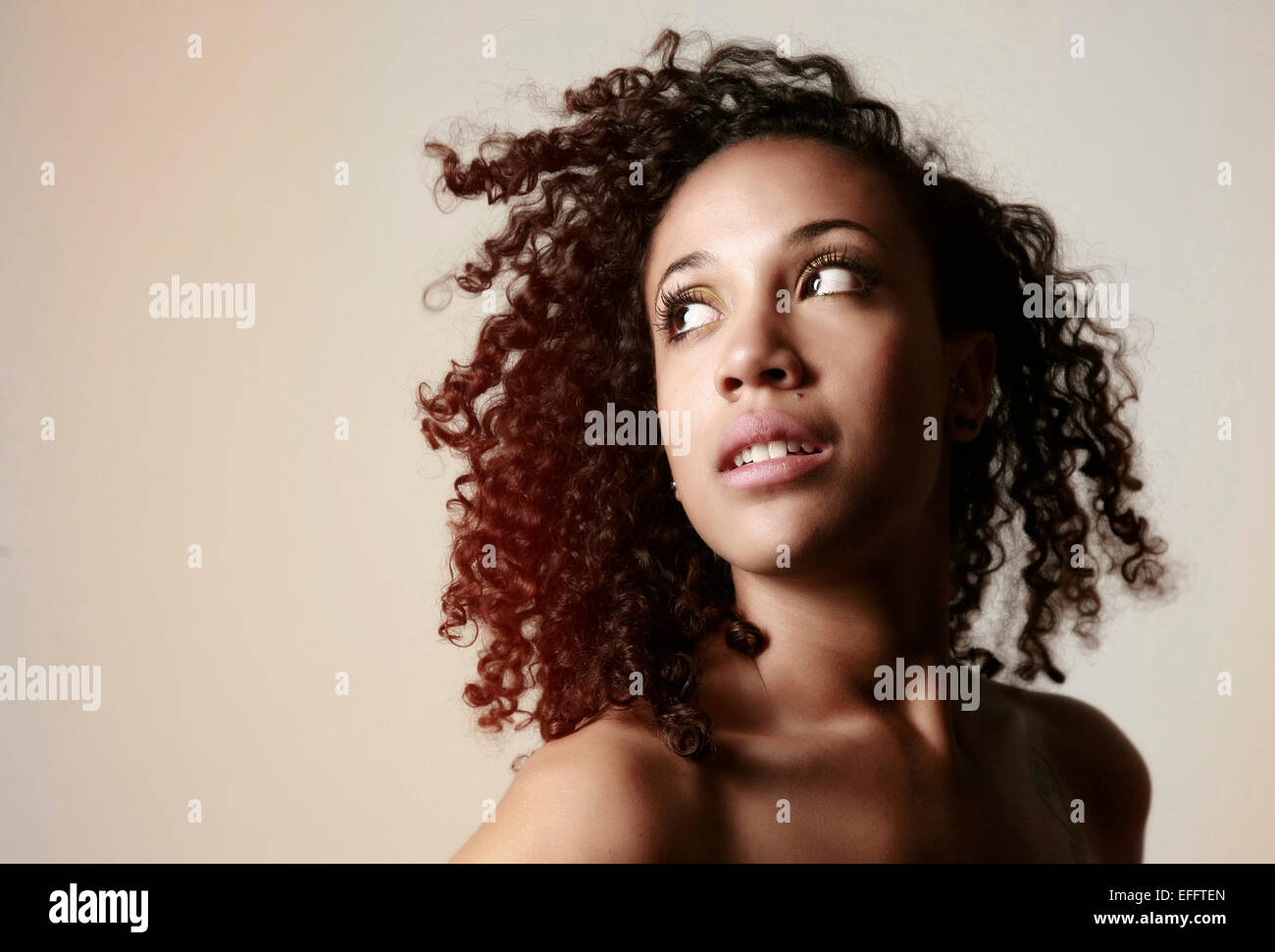 Portrait of young woman with Afro looking up Stock Photo - Alamy
