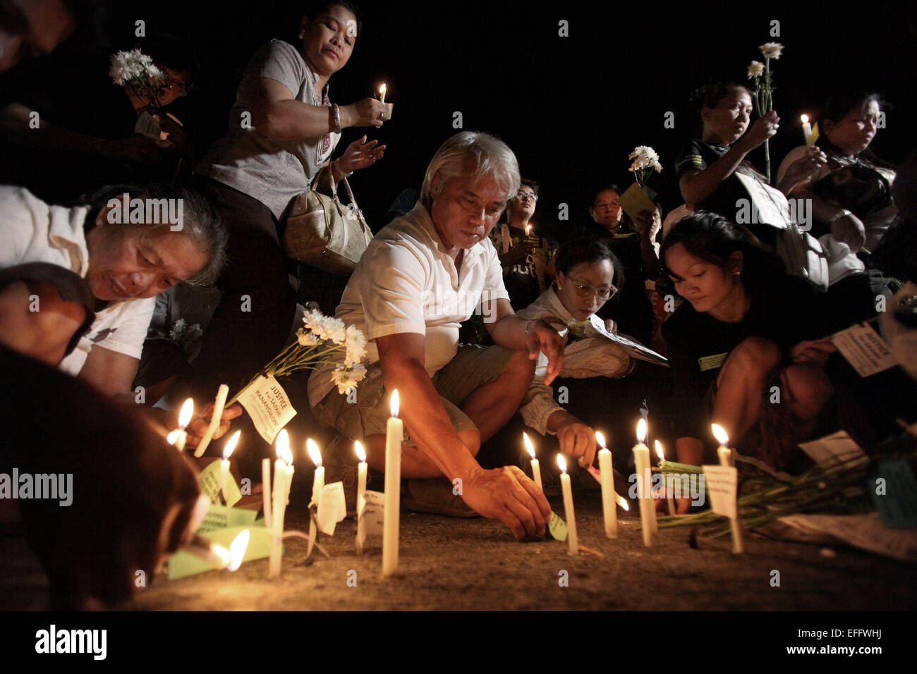 Quezon City, Philippines. 3rd Feb, 2015. People light candles and offer flowers and prayers for the slain 49 members of the Philippine National Police Special Action Force (PNP-SAF) at the gate of the PNP Headquarters in Quezon City, the Philippines, Feb. 3, 2015. There was lack of coordination and planning between the military forces and the leadership of the PNP-SAF during the violent clash in Mamasapano, Maguindanao on Jan. 25, chief of the Armed Forces of the Philippines said on Tuesday. © Rouelle Umali/Xinhua/Alamy Live News Stock Photo