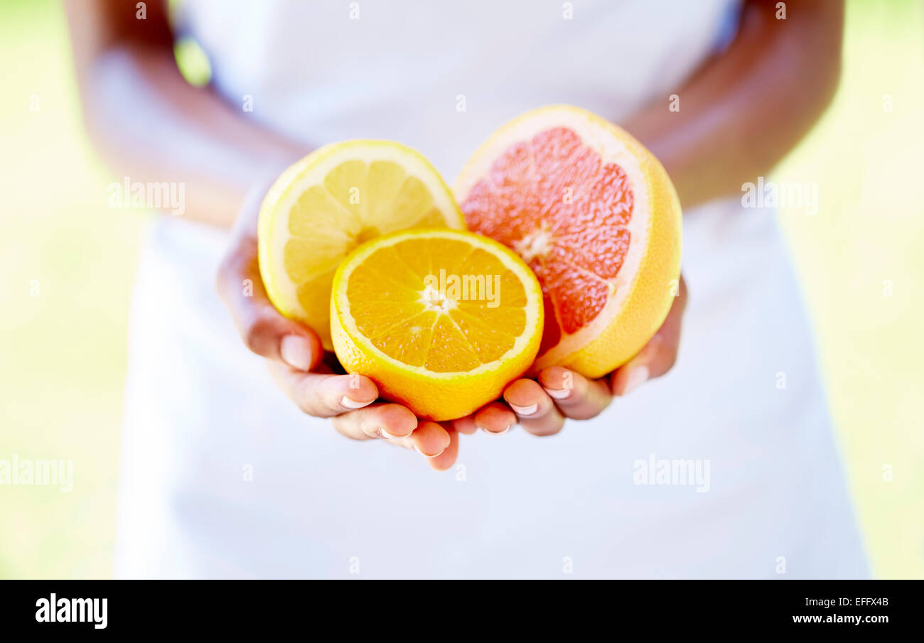 Human hand holding half orange hi-res stock photography and images - Alamy