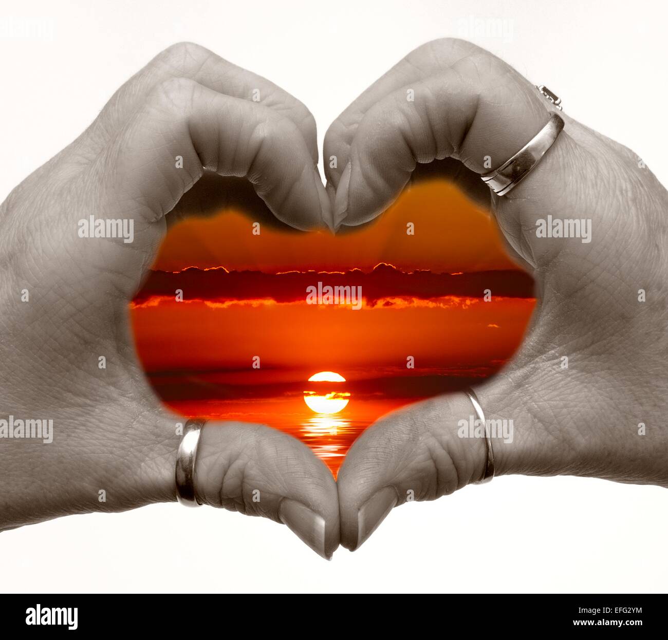 Female hands in a heart shape with a sunset digitally added Stock Photo ...