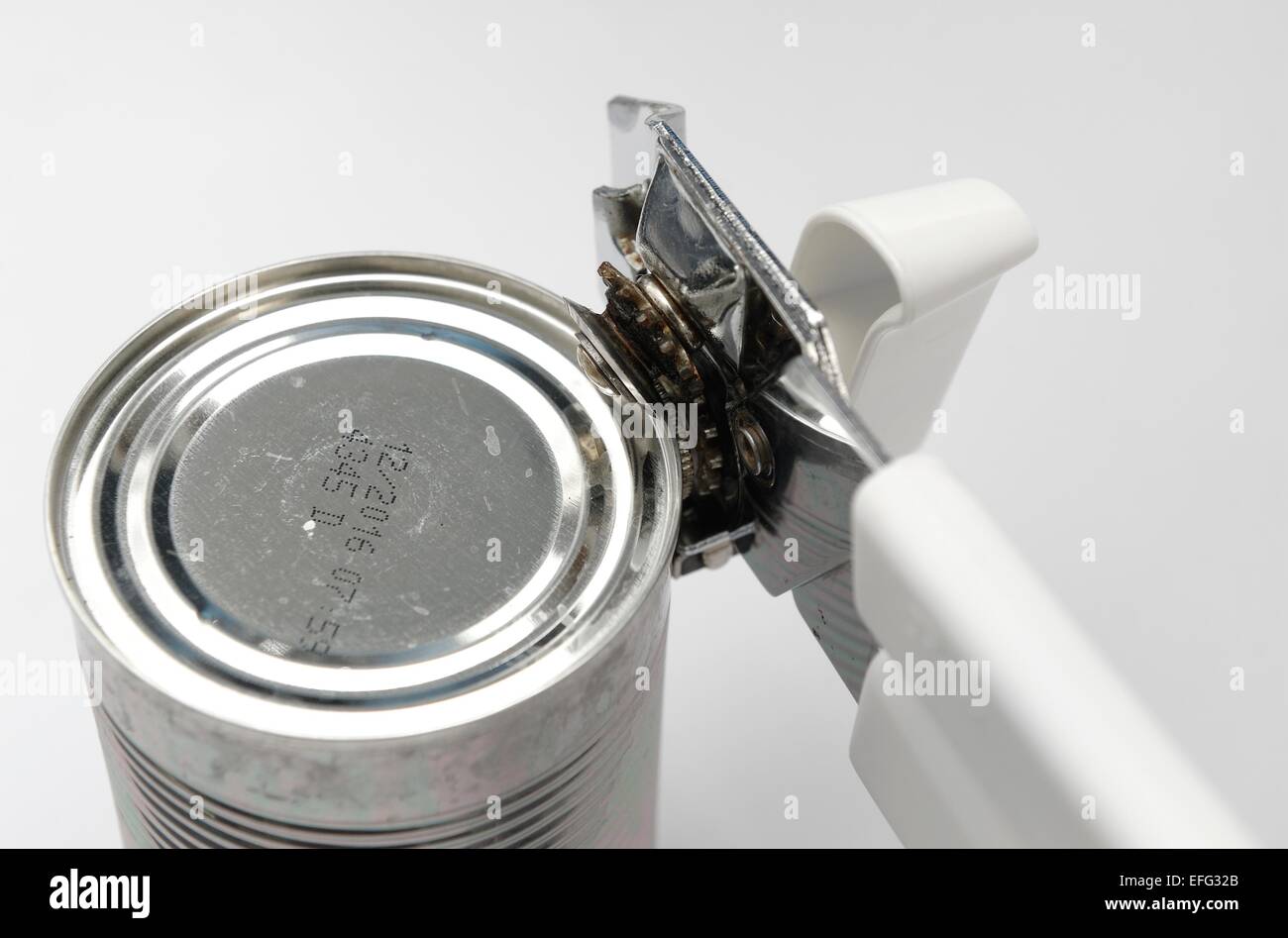 A tin can being opened with a hand can opener Stock Photo Alamy