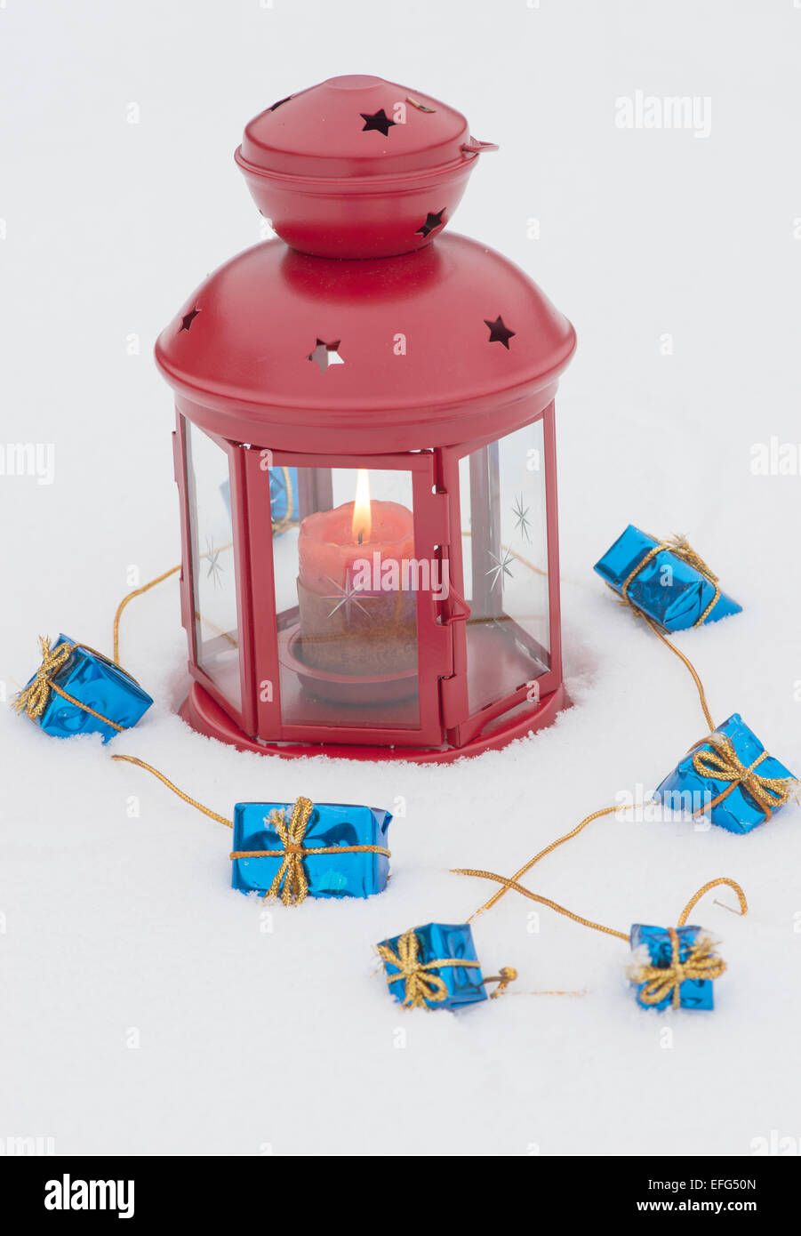 Lamp and little gifts on a snowy background Stock Photo