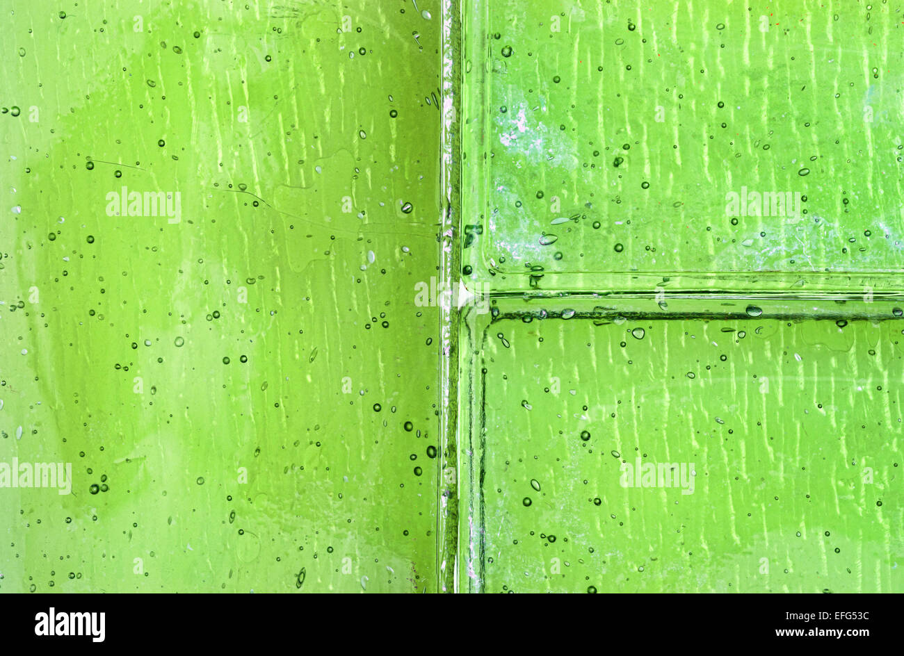A very close view of green tinted glass tiles with air bubbles. Stock Photo