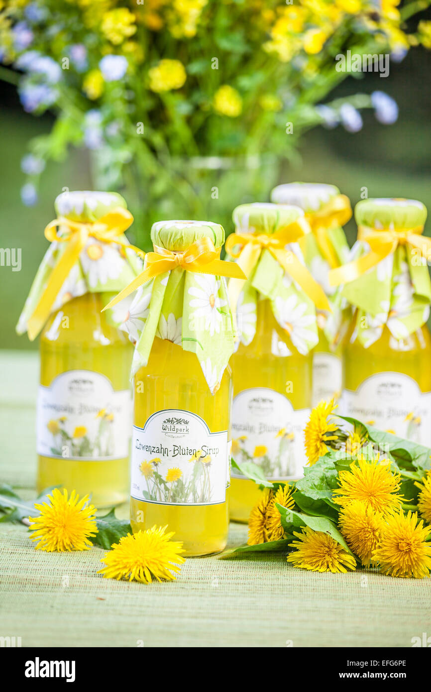 Bottles with dandelion flower syrup in the garden Stock Photo