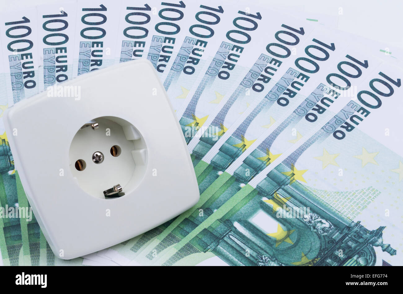 Image shows a white power socket with some banknotes Stock Photo