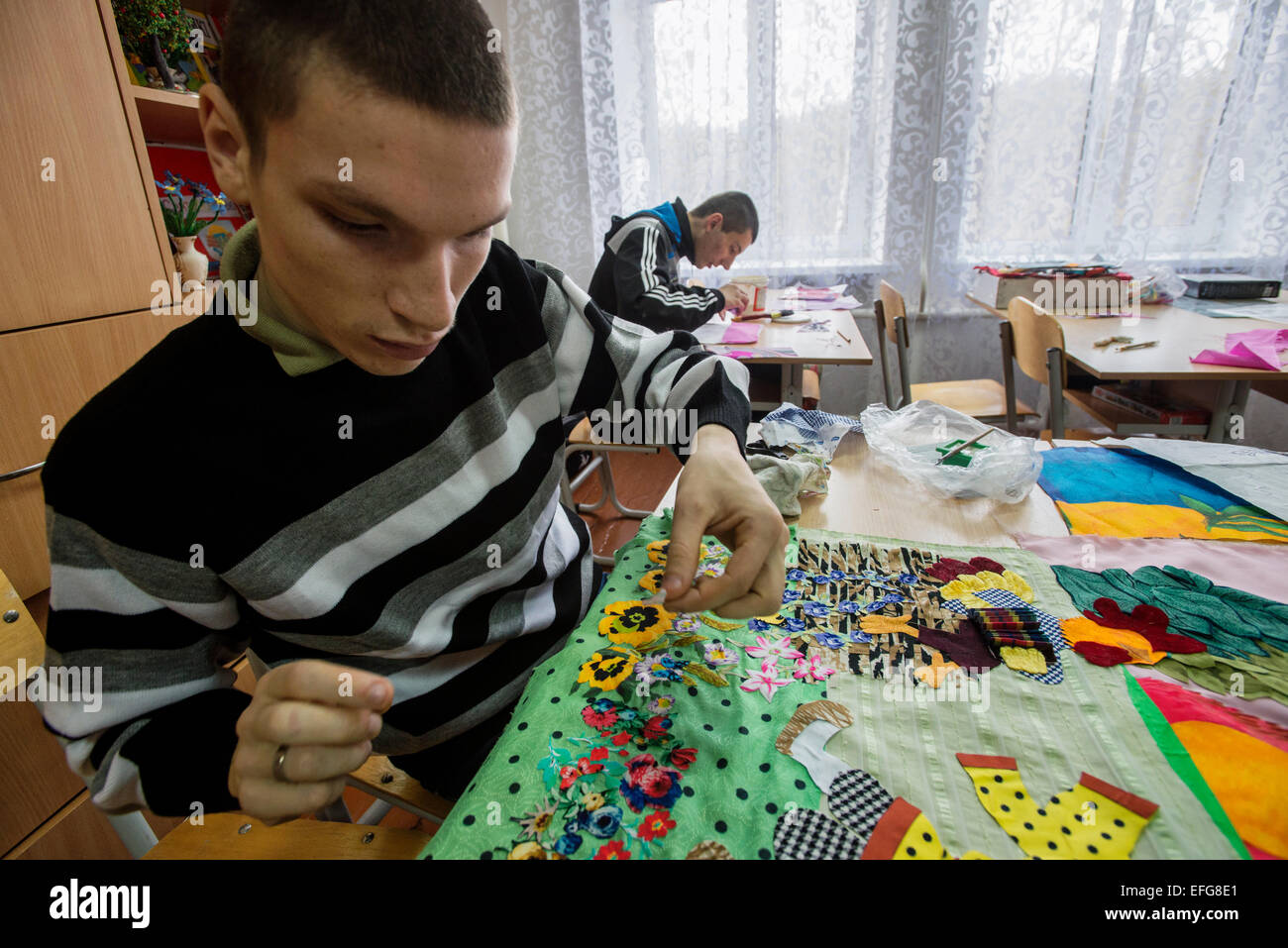 Zhytomyr, Ukraine. 2 of February, 2015. Teterivka's Orphanage and Boarding school has 85 pupils with mental and intellectual disorders, that can't manage without medical and specialists care. Governmental founding is sole way of founding for orphanage. Boys with intellectual disability make textile applique in working class, Teterivka's Orphanage and Boarding school. Zhytomyr, Ukraine. 2 of February, 2015. Credit:  Oleksandr Rupeta/Alamy Live News Stock Photo