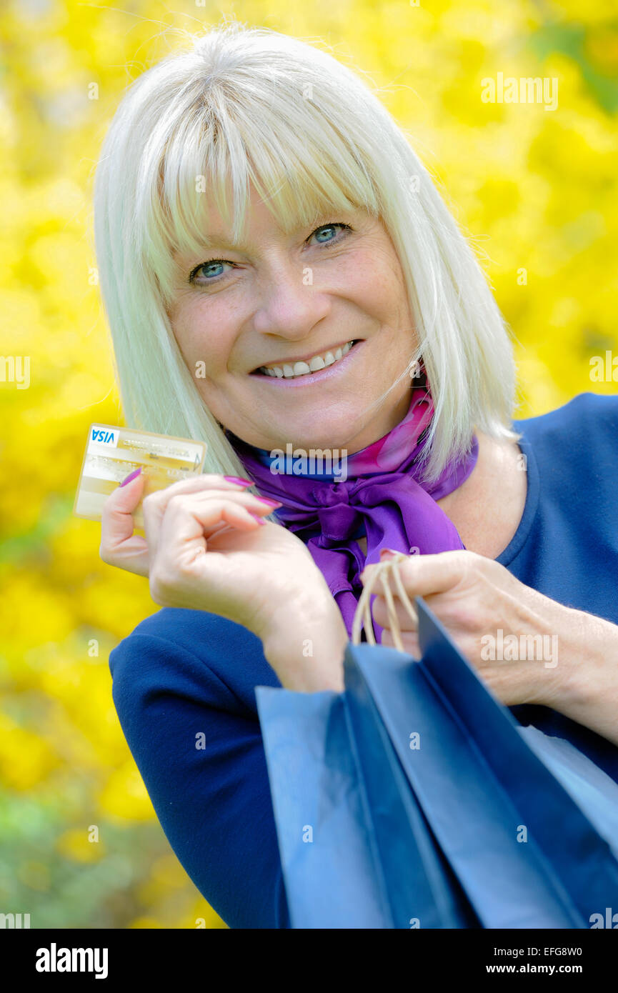 Elderly woman carrying shopping bags hires stock photography and