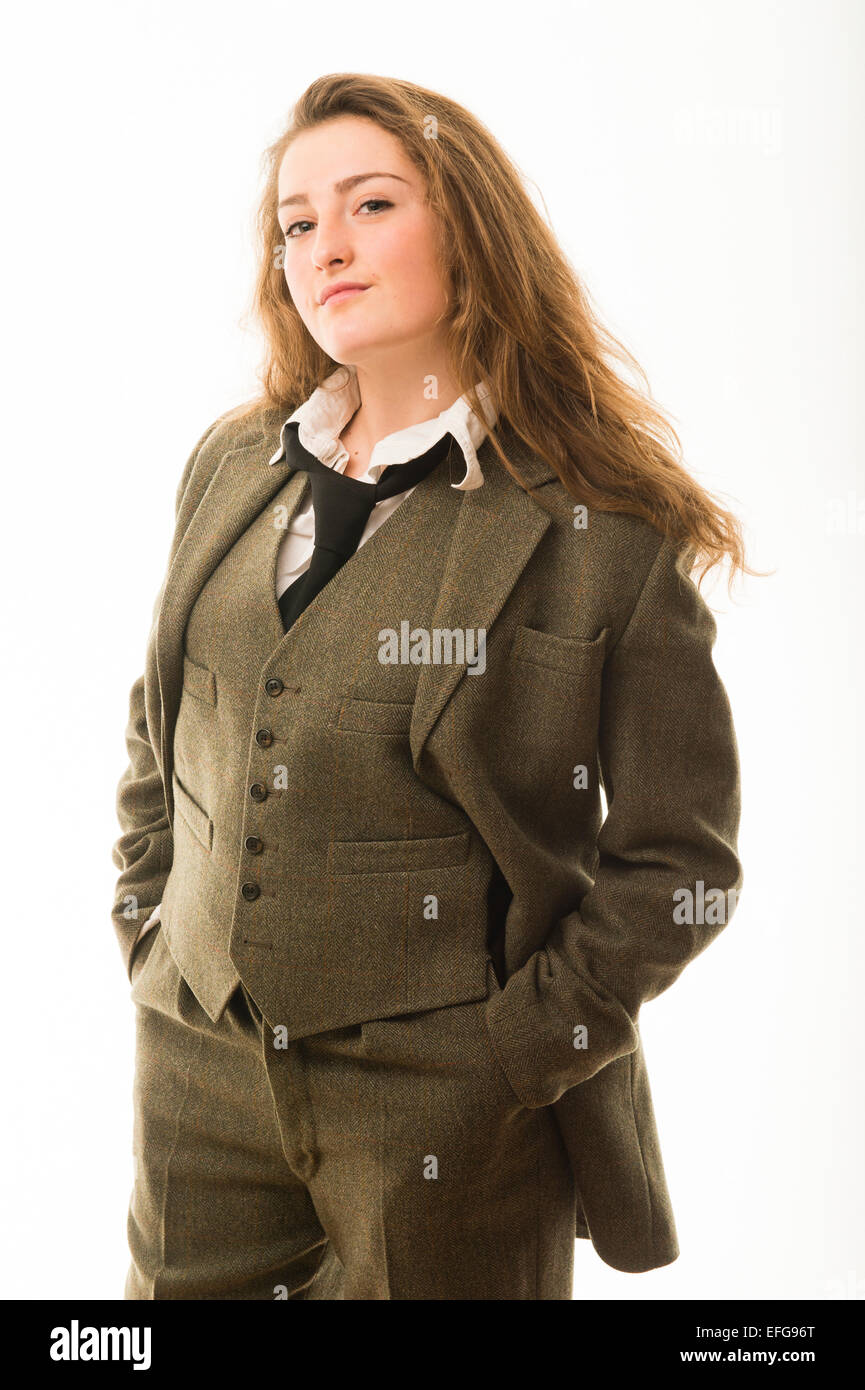 Cross-dressing / masculinity : A pretty fourteen 14 year old teenage girl with long brown hair, wearing a man's masculine clothes - green three piece traditional tweed suit shirt and tie  UK Stock Photo