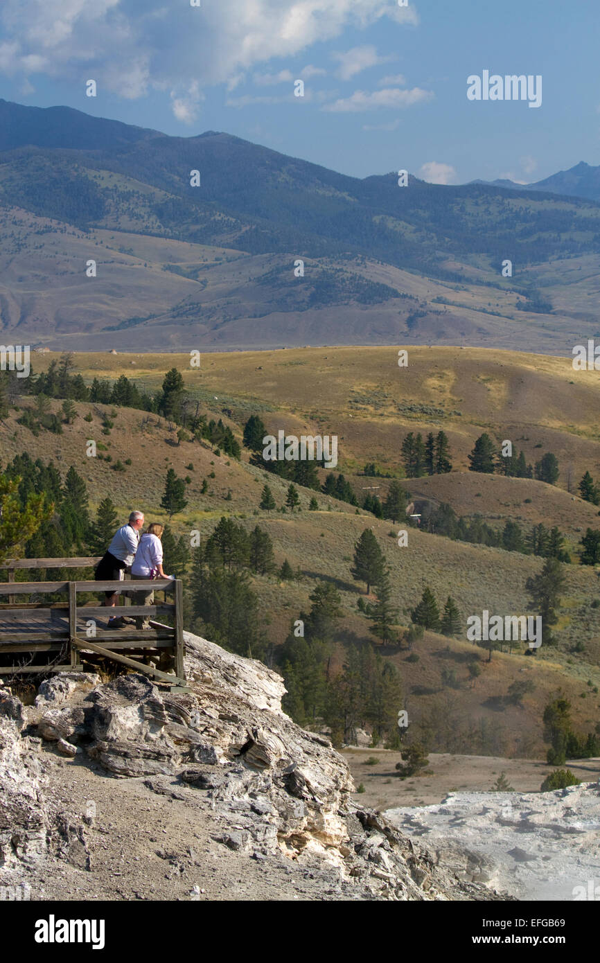Tourists stand at a scenic overlook near Mammoth Hot Springs in Yellowstone National Park, Wyoming, USA. Stock Photo