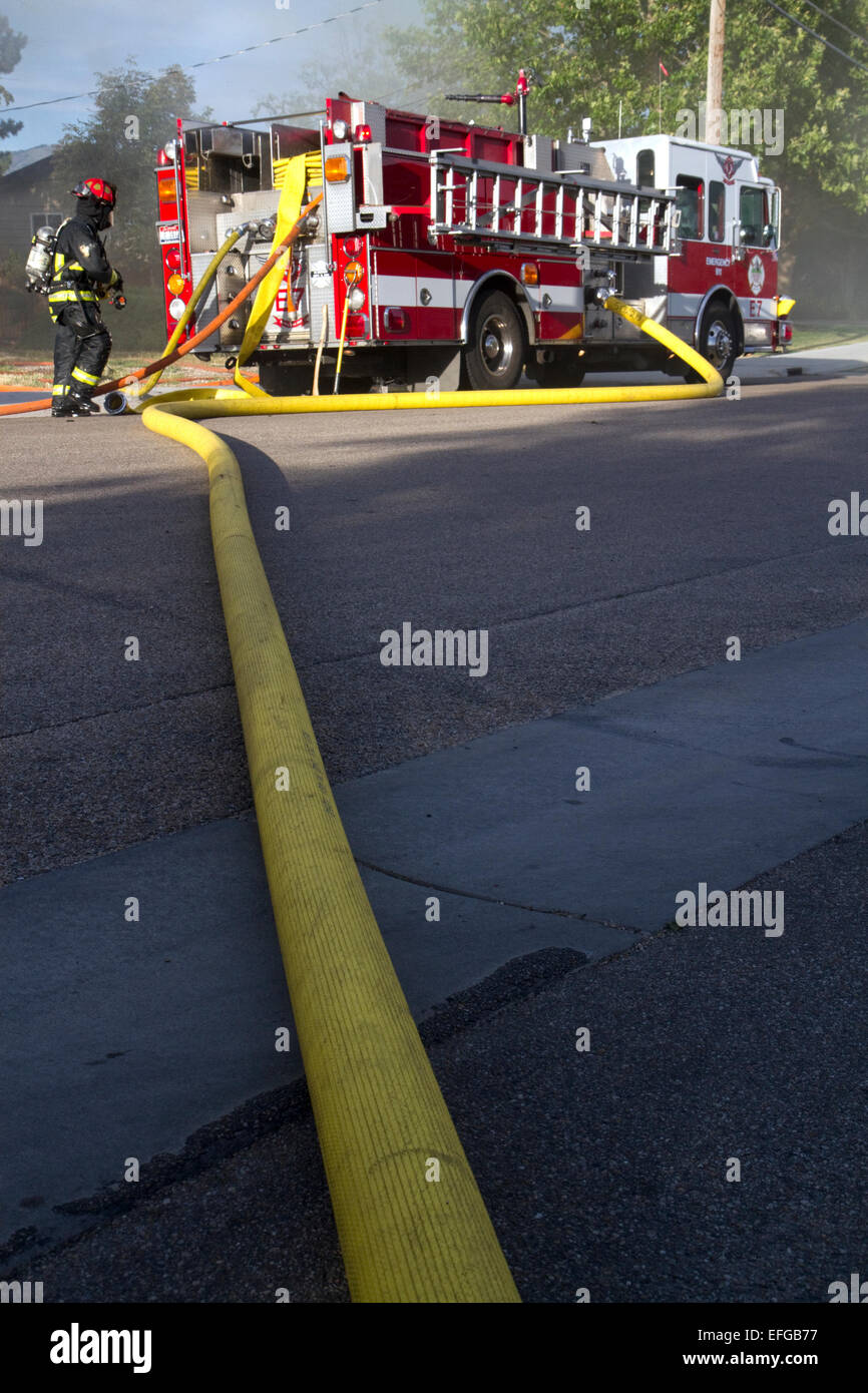Water supply hose from a pumper fire truck at the scene of a residential fire in Boise, Idaho, USA. Stock Photo