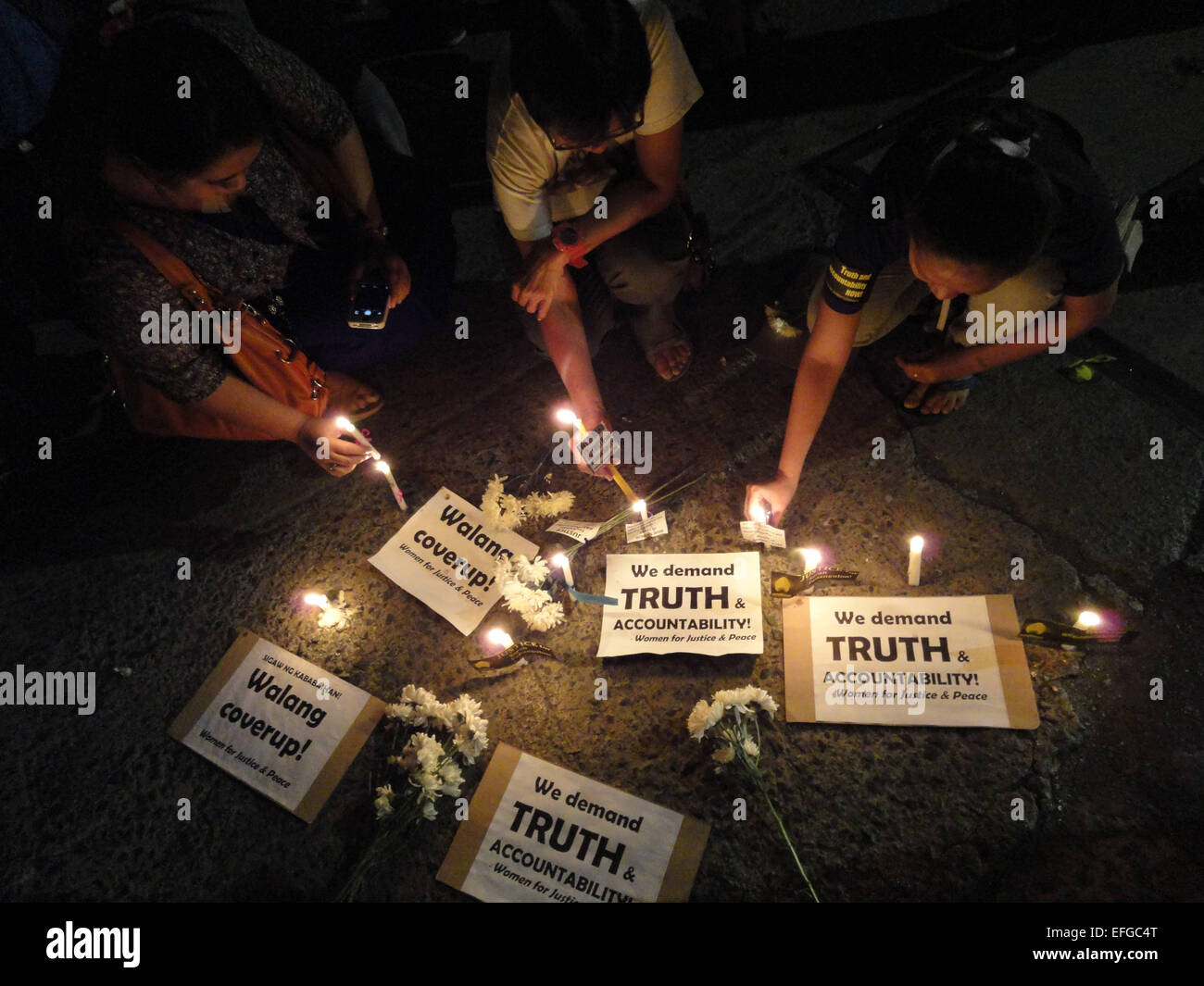 Quezon City, Philippines. 3rd Feb, 2015. Activists light candles alongside placards and flowers outside the Philippine National Police headquarters. A mass was celebrated outside the Philippine National Police headquarters as they called for truth and accountability for the casualties of the botched anti-terror operation in Mamasapano, Maguindanao provionce last January 25, including 44 police commandos, as well as several civilians. Credit:  Richard James Mendoza/Pacific Press/Alamy Live News Stock Photo