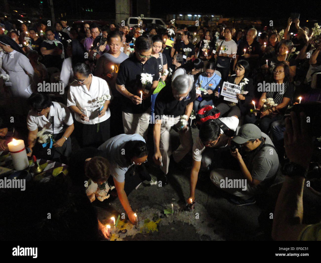 Quezon City, Philippines. 3rd Feb, 2015. Former congressmen Satur Ocampo and Teddy Casino, fourth and fifth from left, take turns in placing candles outside the Philippine National Police headquarters. A mass was celebrated outside the Philippine National Police headquarters as they called for truth and accountability for the casualties of the botched anti-terror operation in Mamasapano, Maguindanao provionce last January 25, including 44 police commandos, as well as several civilians. Credit:  Richard James Mendoza/Pacific Press/Alamy Live News Stock Photo