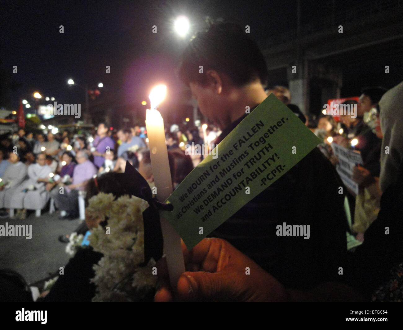 Quezon City, Philippines. 3rd Feb, 2015. A candle tied with a black ribbon and a small note is held outside the Philippine National Police headquarters. A mass was celebrated outside the Philippine National Police headquarters as they called for truth and accountability for the casualties of the botched anti-terror operation in Mamasapano, Maguindanao provionce last January 25, including 44 police commandos, as well as several civilians. Credit:  Richard James Mendoza/Pacific Press/Alamy Live News Stock Photo