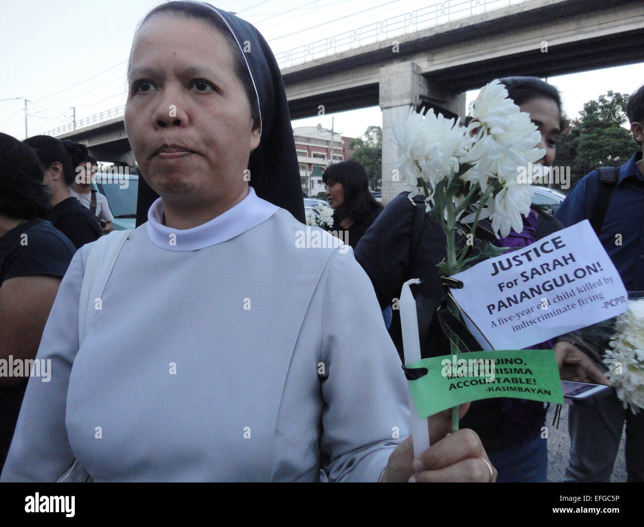 Quezon City, Philippines. 3rd Feb, 2015. A nun holds a flower tied with messages calling for justice outside the Philippine National Police headquarters. A mass was celebrated outside the Philippine National Police headquarters as they called for truth and accountability for the casualties of the botched anti-terror operation in Mamasapano, Maguindanao provionce last January 25, including 44 police commandos, as well as several civilians. Credit:  Richard James Mendoza/Pacific Press/Alamy Live News Stock Photo