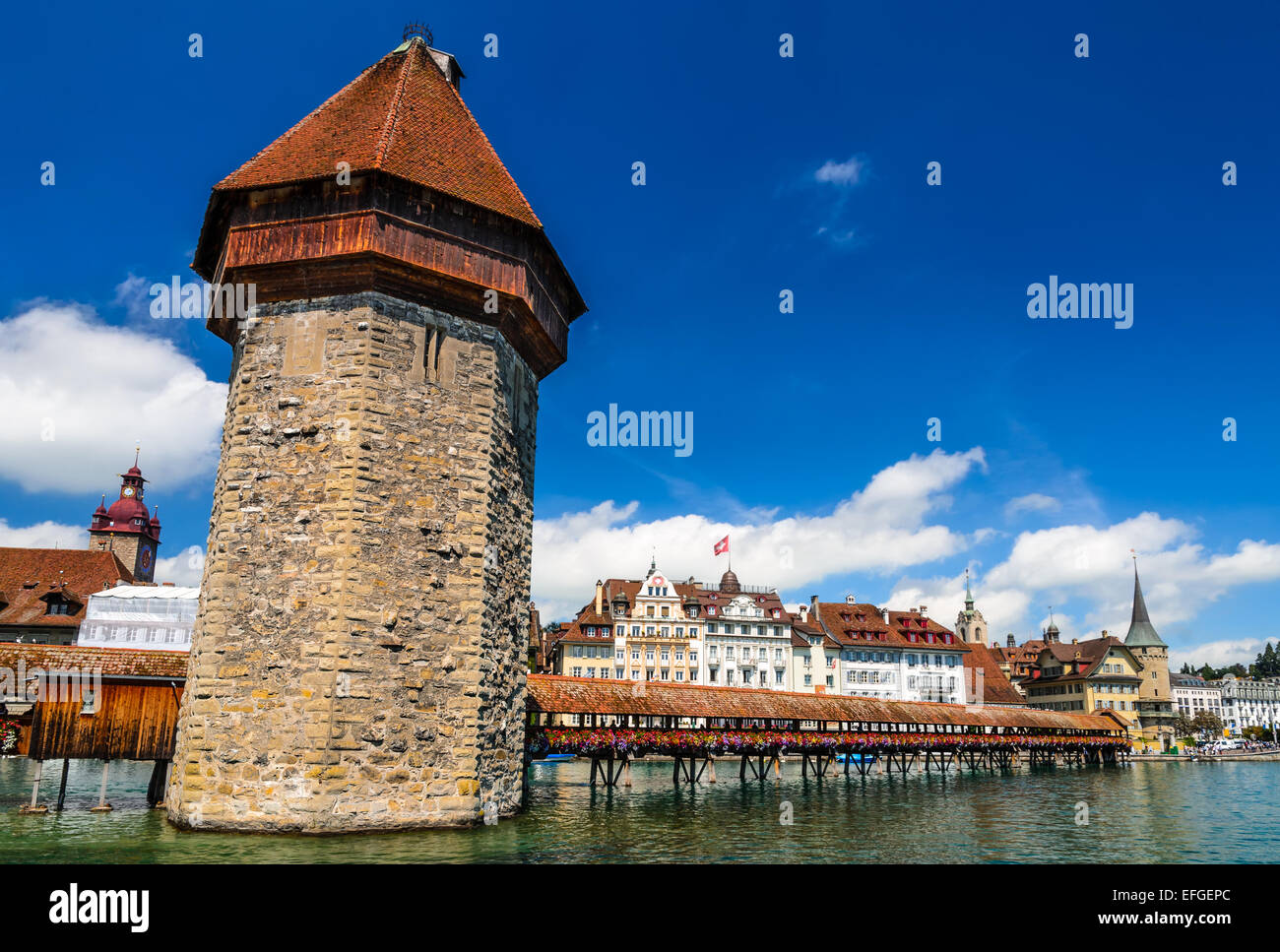 A view of the famous wooden Chapel Bridge of Luzerne, Lucerne in Switzerland, with the water tower and Reuss River. Stock Photo