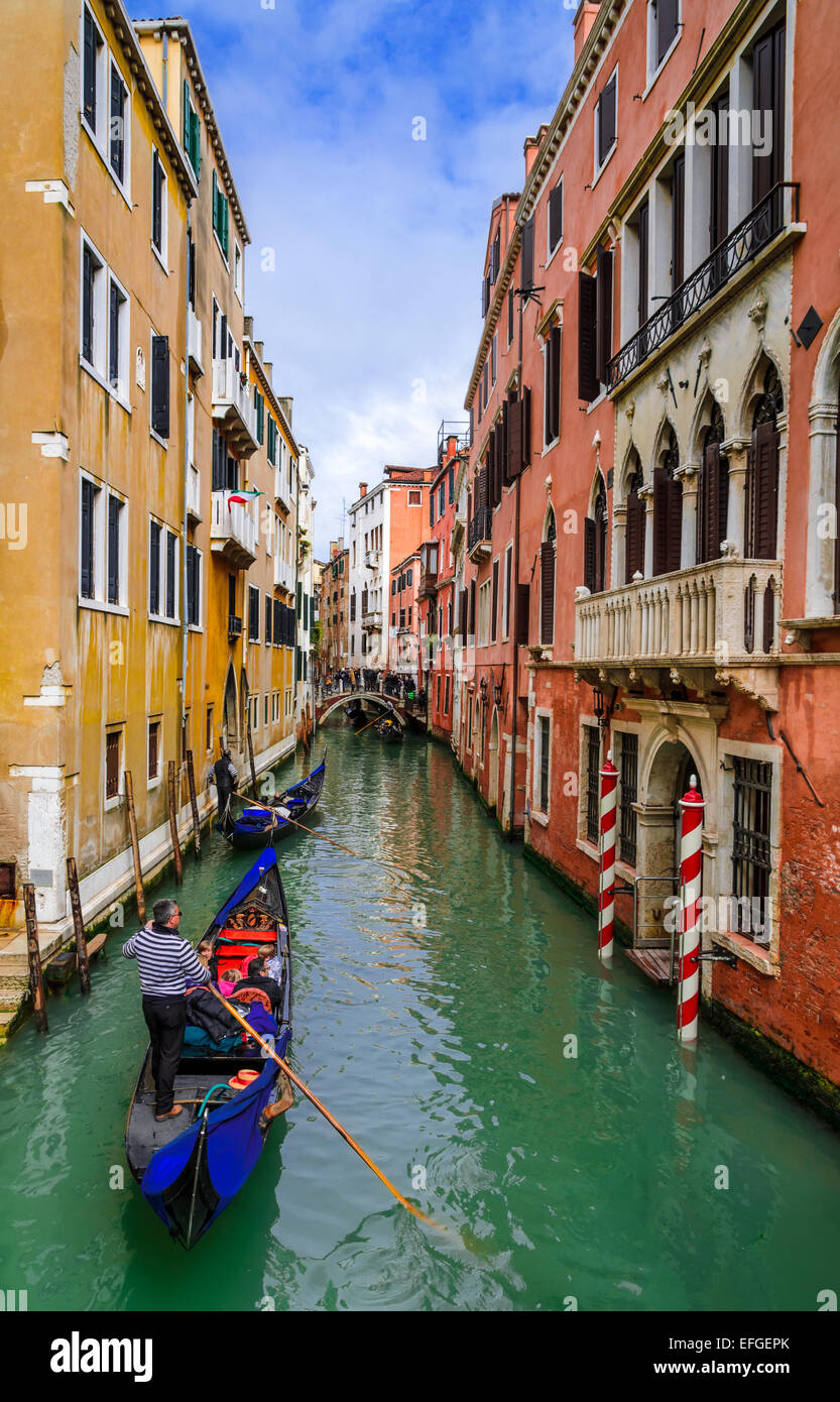 Venice, Italy. Image with tourists and gondola on small channel of Venice. Gondola is a traditional Venetian row Stock Photo