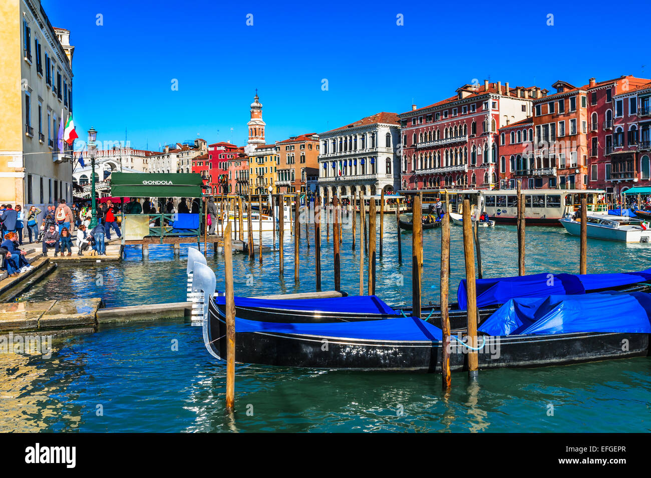 Venice, Italy. Image with gondola docked on Grand Canal and Ponte di Rialto (Rialto Bridge) in Venice. Stock Photo