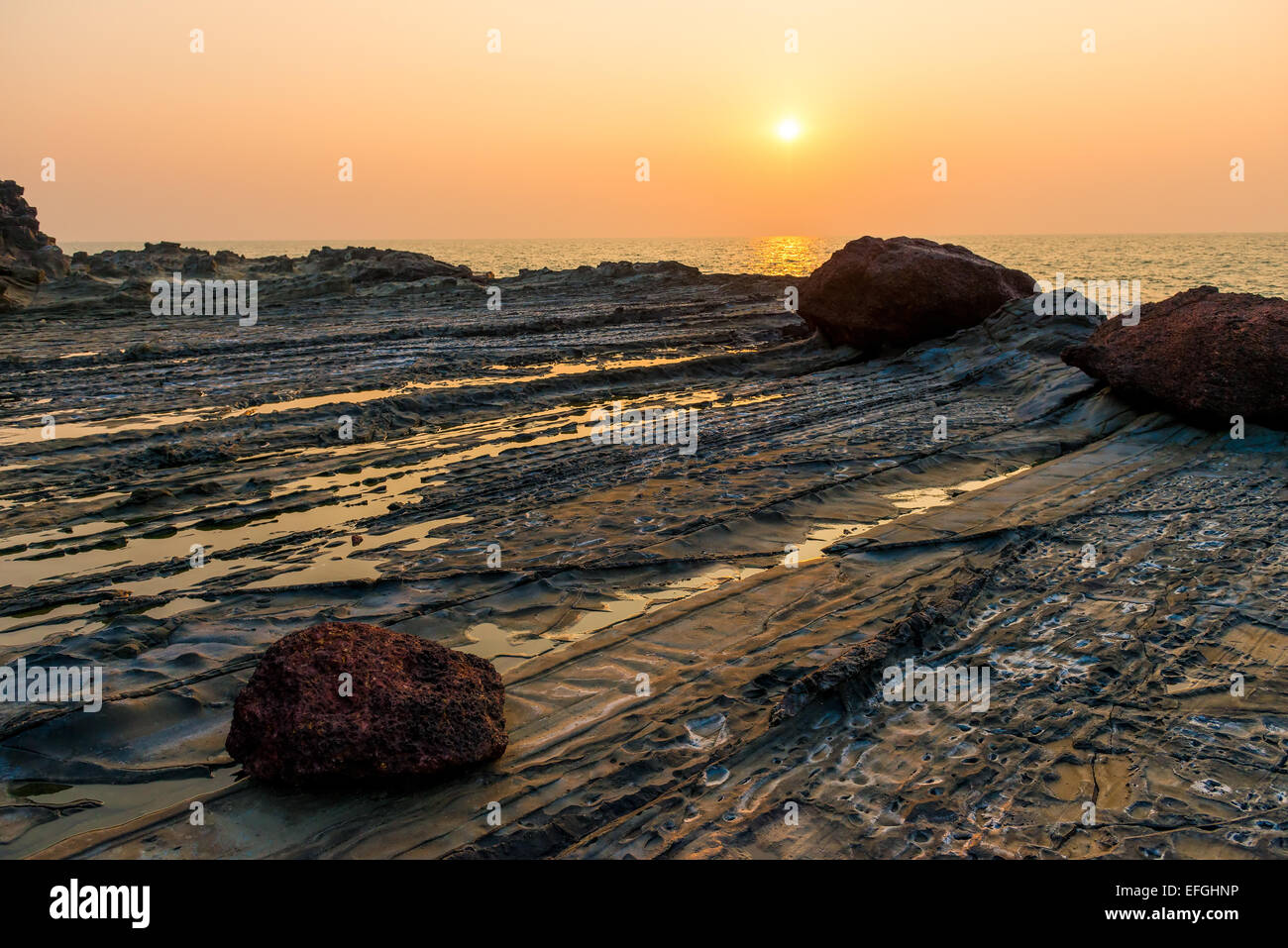 beautiful sunset over the sea and rocky Stock Photo - Alamy
