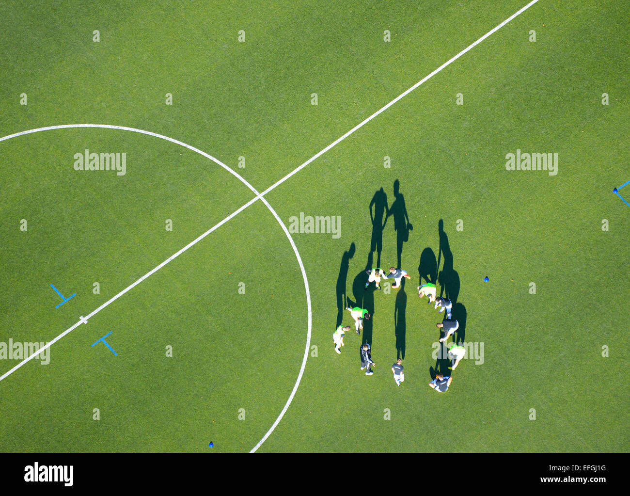 Football team, football players doing warmup exercises, aerial view
