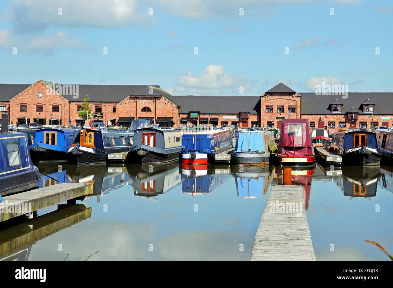 Narrowboats on their moorings in the canal basin with shops, bars and
