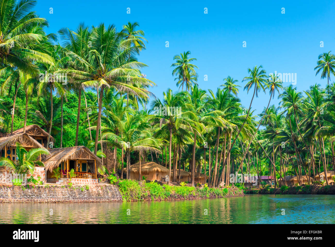 tropical palms and bungalows to relax from the hectic Stock Photo
