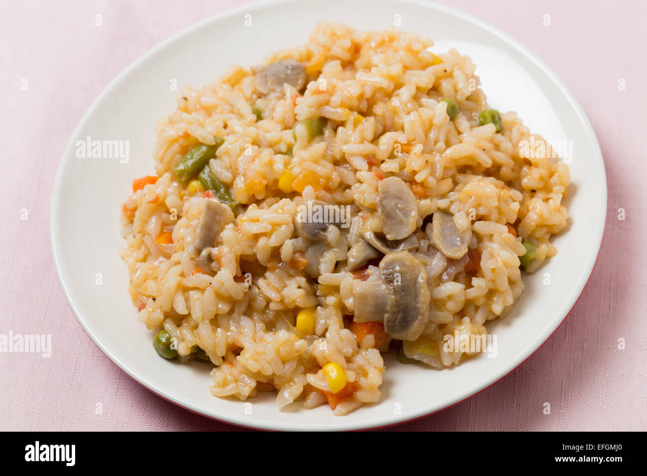 A meal of vegetable risotto with mushrooms, sweetcorn, carrot, green