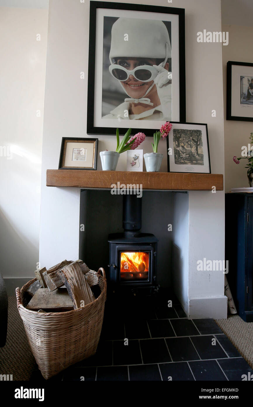 A wood burner and basket of logs. Stock Photo