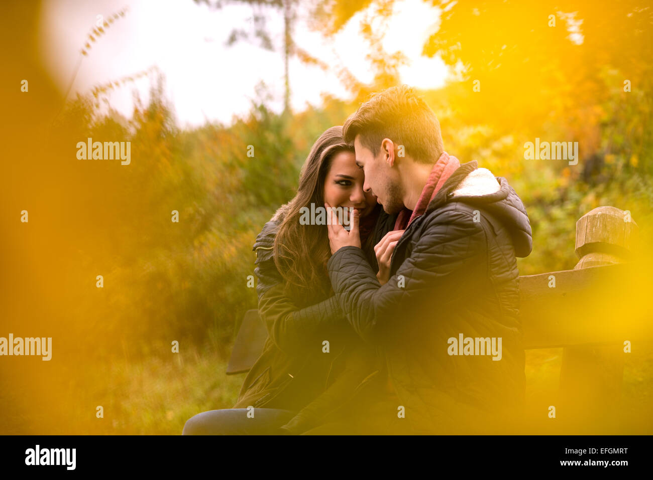 Loving couple in the autumn park sitting on a bench Stock Photo - Alamy