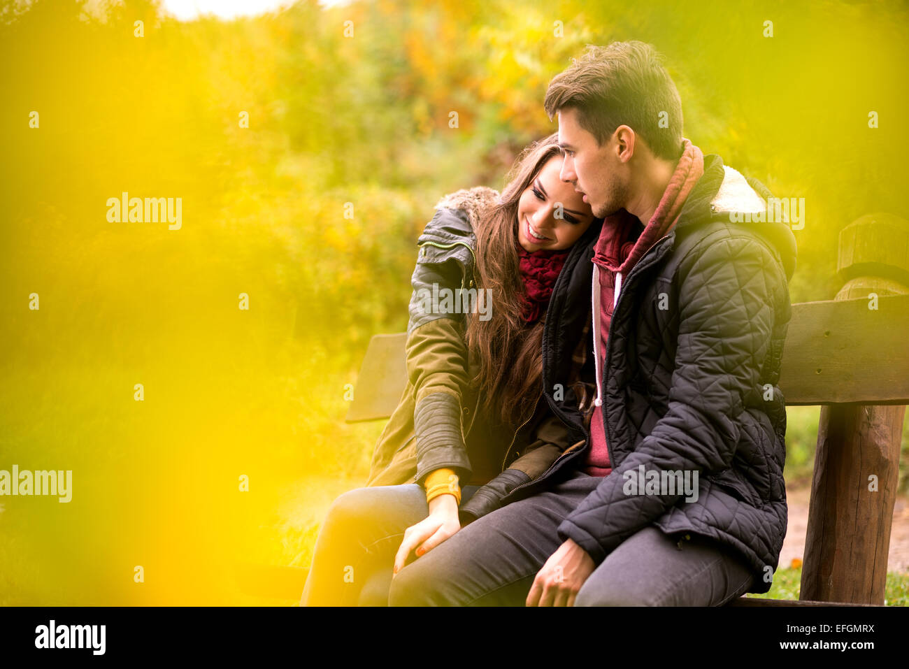 Loving couple in the autumn park sitting on a bench Stock Photo - Alamy