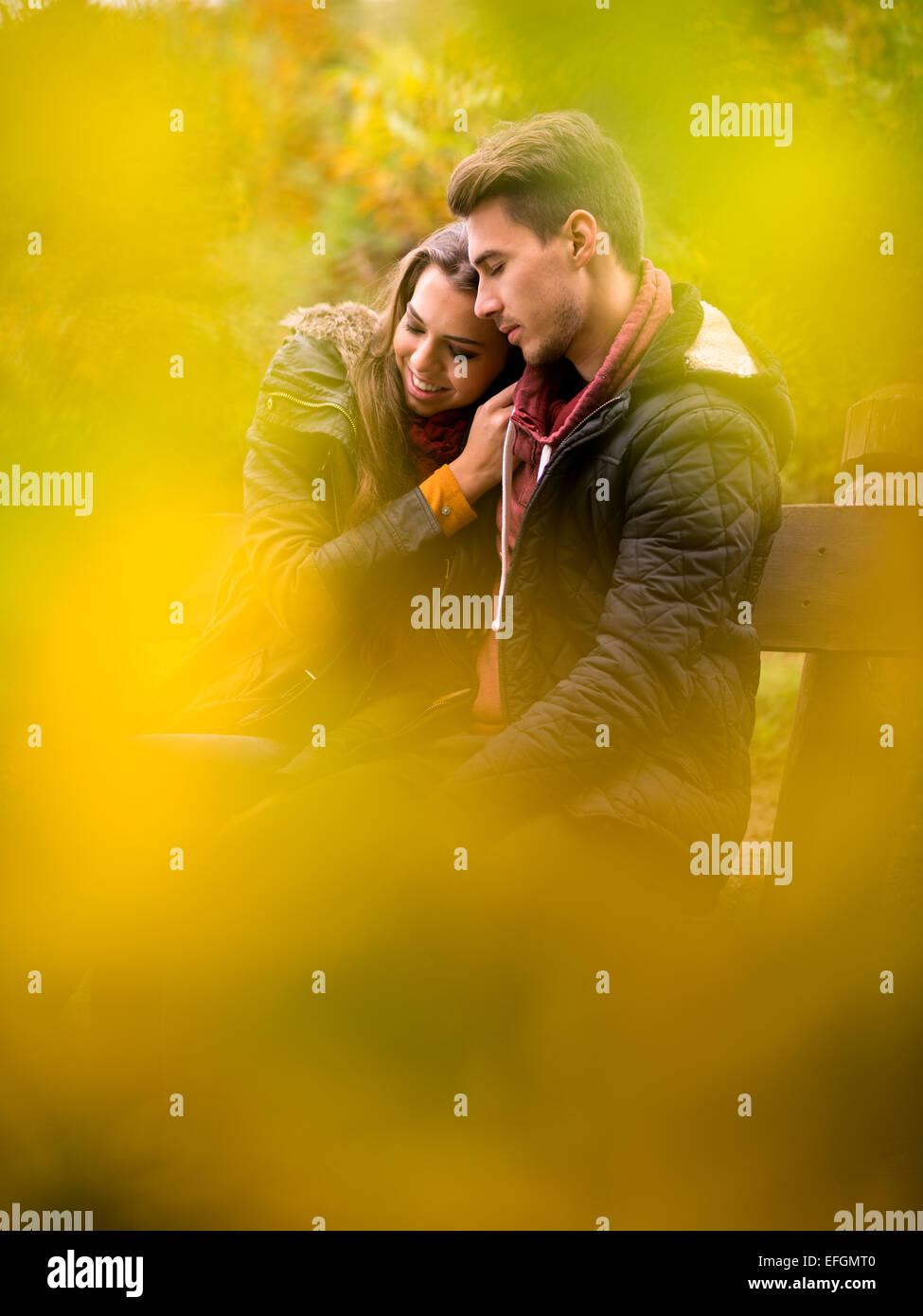 Loving couple in the autumn park sitting on a bench Stock Photo - Alamy