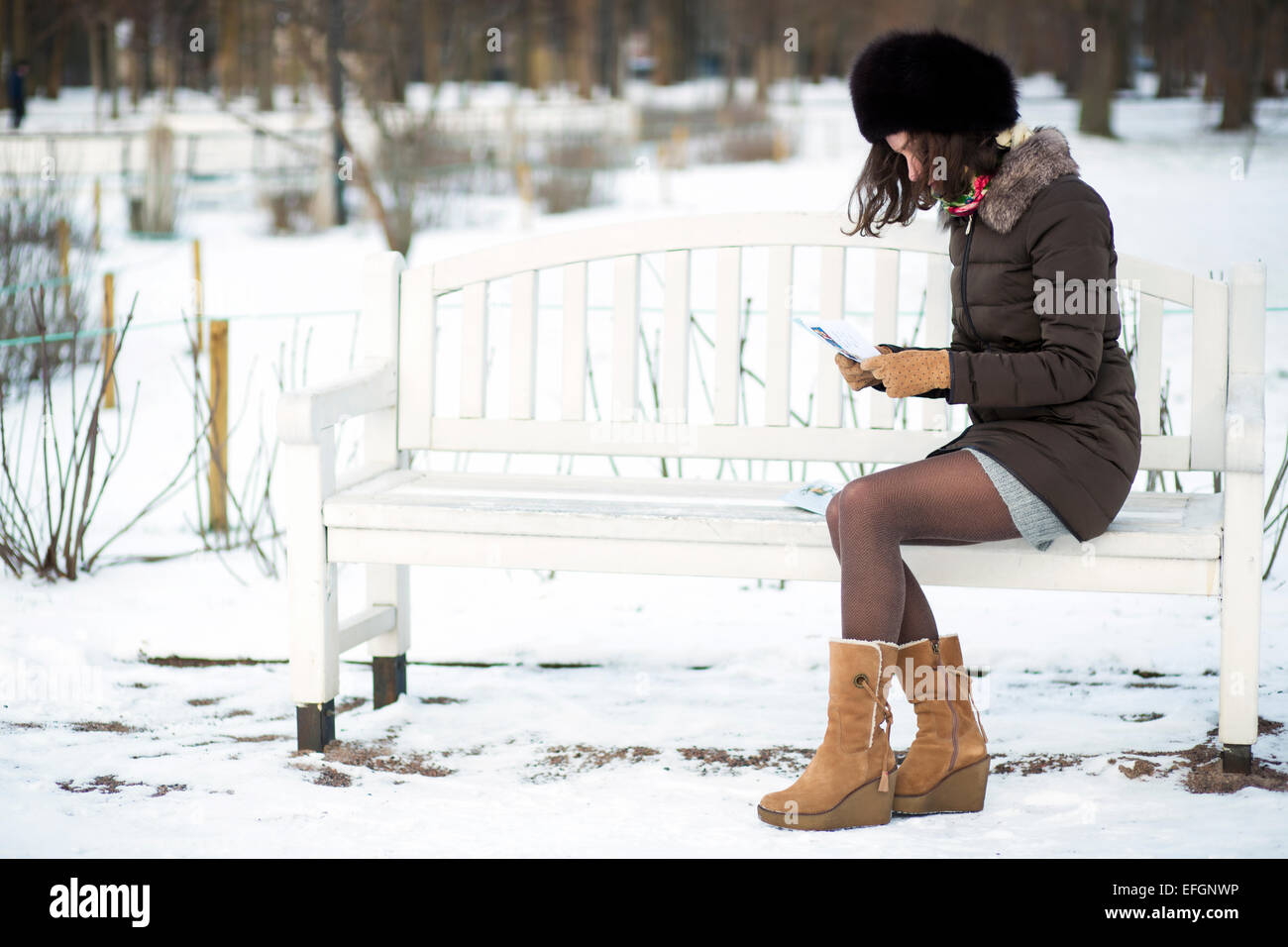 Lady on a bench sits reading a letter Stock Photo - Alamy