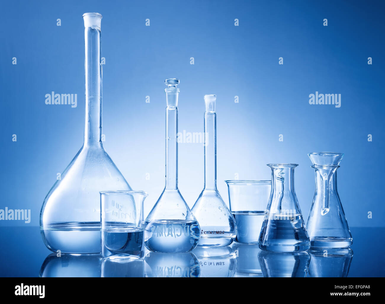Laboratory equipment, bottles, flasks on blue background Stock Photo