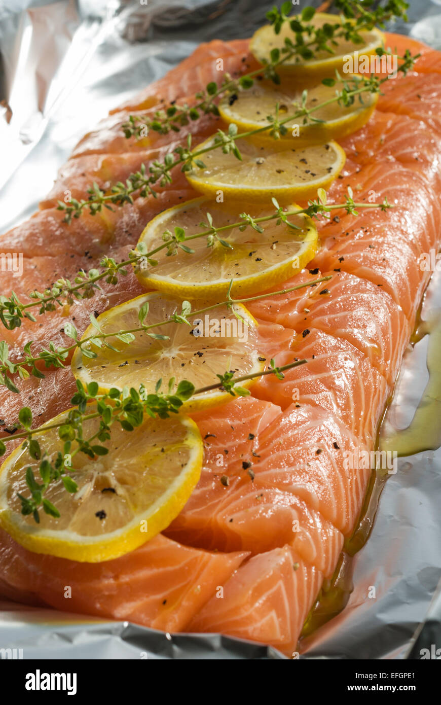 Side of fresh, raw, salmon (salmon fillets) with lemon and herbs on tin