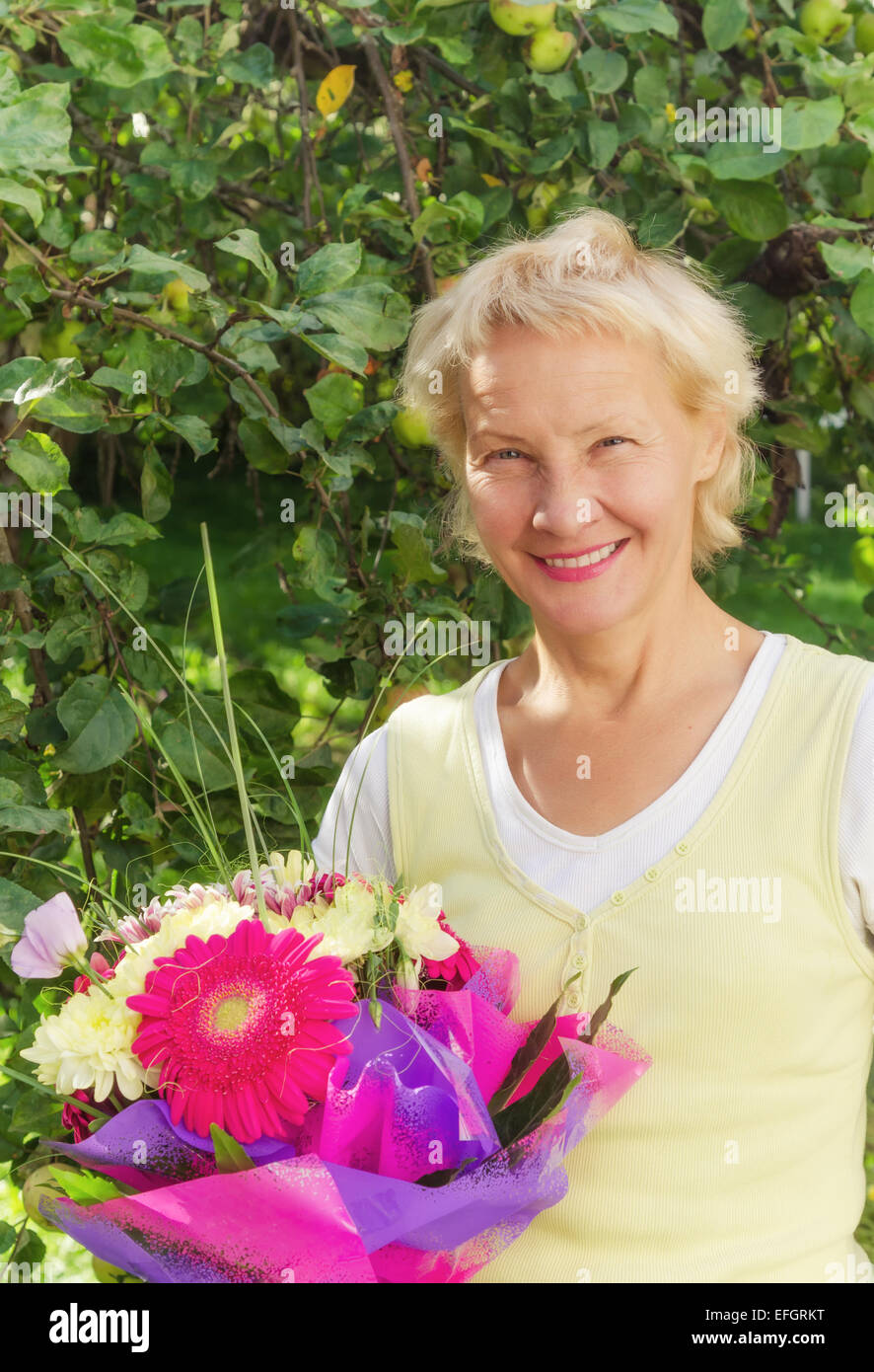 Portrait of a woman in the garden with a bouquet of flowers Stock Photo ...