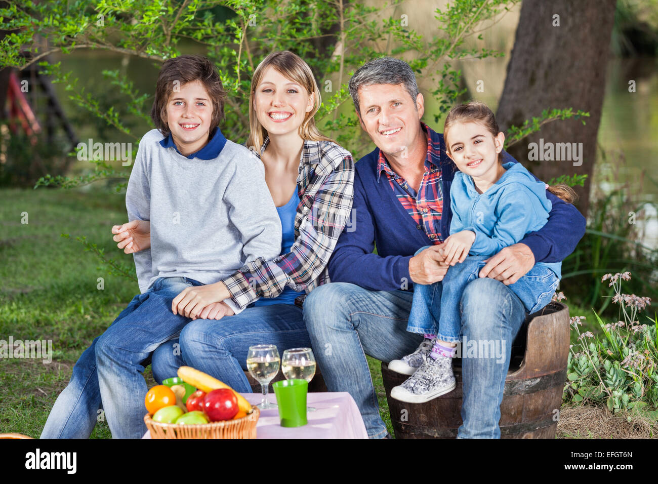 Family Sitting On Chairs At Campsite Stock Photo