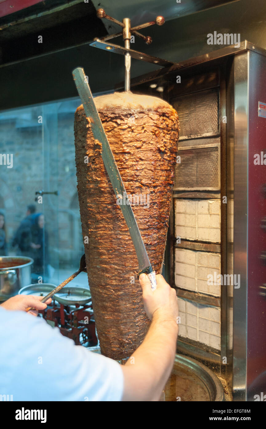 Doner kebab Turkish döner is being cut before serving by chef at restaurant in istanbul Turkey Stock Photo