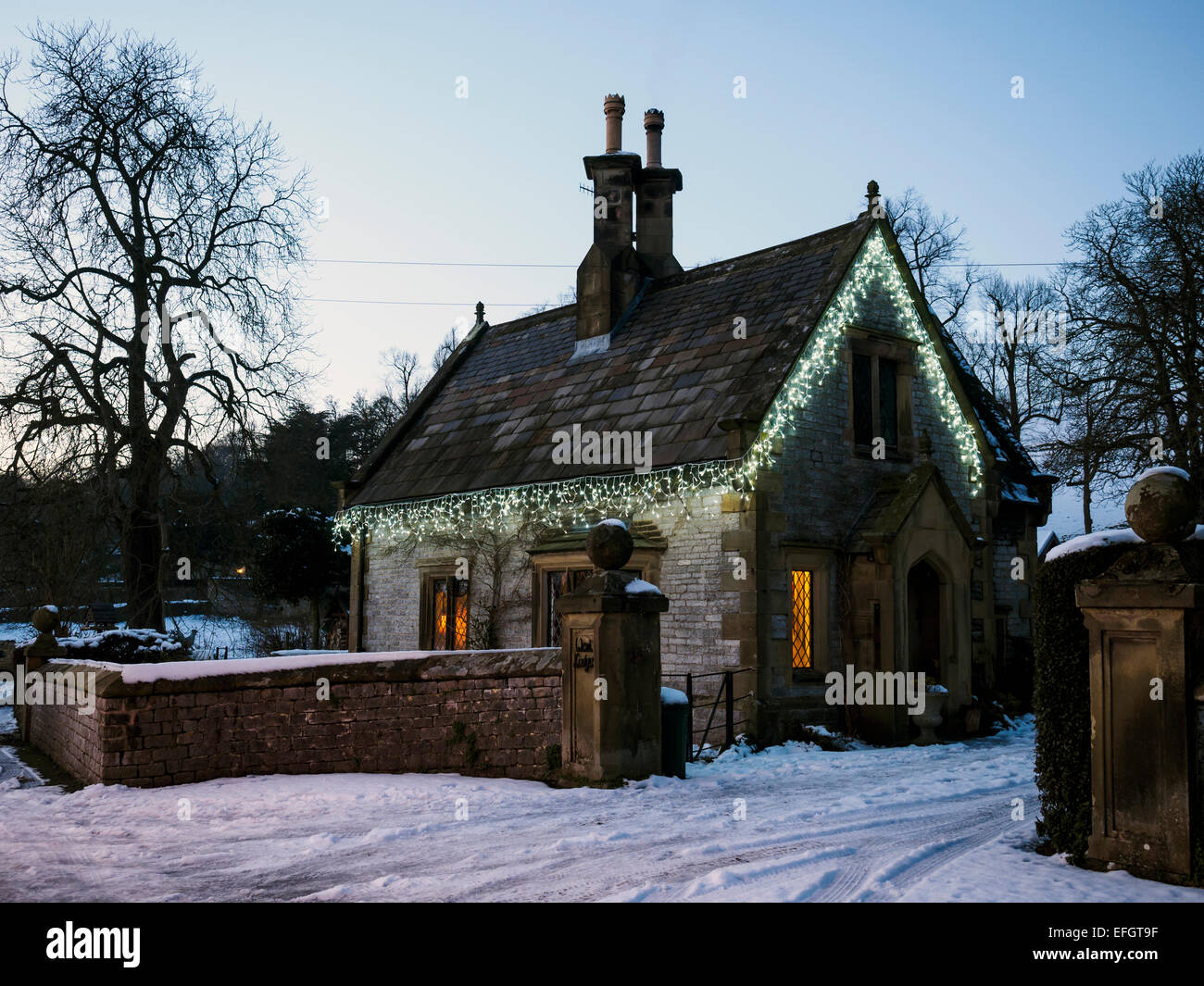 Small stone cottage covered in Christmas lights Derbyshire England